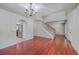 Open-concept living room featuring hardwood floors, staircase, and arched doorway leading to a kitchen at 8632 Madelyn St, North Charleston, SC 29406