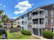 Townhouse exterior with balconies and well-maintained lawn and garden, perfect for outdoor relaxation at 9206 Southern Oak Ln, Ladson, SC 29456