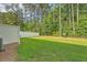 Well-manicured backyard featuring lush green grass and a white fence line surrounded by a tall treeline at 9418 Sweep Dr, Summerville, SC 29485