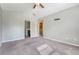 View of a carpeted bedroom with light gray walls, ceiling fan, closet, and two doorways at 9418 Sweep Dr, Summerville, SC 29485