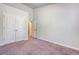 A simplistic bedroom featuring a neutral carpet, closet, and access to an open doorway at 9418 Sweep Dr, Summerville, SC 29485