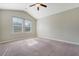 Carpeted bedroom with a ceiling fan, light gray walls, and large windows overlooking the yard at 9418 Sweep Dr, Summerville, SC 29485