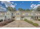 Street view showcasing charming townhomes with colorful exteriors, attached garages, and manicured landscaping at 9418 Sweep Dr, Summerville, SC 29485