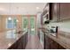 Modern kitchen features granite counters, an island, stainless appliances, and access to the backyard, perfect for cooking and entertaining at 9418 Sweep Dr, Summerville, SC 29485