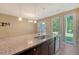 Well-appointed kitchen featuring granite countertops, a large island, stainless steel appliances, and sliding glass doors to backyard at 9418 Sweep Dr, Summerville, SC 29485