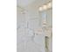 Bathroom with white marble, shower-tub combination and modern fixtures and lighting at 1 Vendue Range # I, Charleston, SC 29401