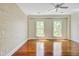 Bright bedroom features hardwood floors, textured wall, three windows, and white ceiling fan at 1 Vendue Range # I, Charleston, SC 29401