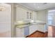 Kitchen area featuring a dishwasher, granite countertop, and custom cabinets with lighting at 1 Vendue Range # I, Charleston, SC 29401