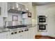 Well appointed kitchen showcases a gas range, modern vent hood, and stainless steel double ovens at 1 Vendue Range # I, Charleston, SC 29401