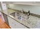 Close up of a kitchen sink with stainless steel faucet and granite countertops at 1 Vendue Range # I, Charleston, SC 29401