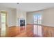 Open living room with a fireplace, gleaming hardwood floors and access to a balcony at 1 Vendue Range # I, Charleston, SC 29401