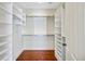 Walk-in closet with custom built-in shelving and hardwood floors at 1 Vendue Range # I, Charleston, SC 29401