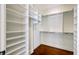 Walk-in closet with white custom built-in shelves and storage at 1 Vendue Range # I, Charleston, SC 29401