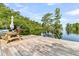 Picturesque dock on a serene lake with an American flag, picnic table, and lush green surroundings at 107 Jacks Ln, Bonneau, SC 29431