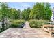 Wooden dock extending into a tranquil lake, complete with a boat and shaded picnic area at 107 Jacks Ln, Bonneau, SC 29431