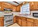 Bright kitchen featuring wood cabinets, granite counters, stainless steel appliances, and tile backsplash at 107 Jacks Ln, Bonneau, SC 29431