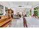 Sunroom featuring tiled floors, lots of windows, piano, and large dining table at 107 Jacks Ln, Bonneau, SC 29431