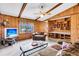 Comfortable living room showcasing wood-paneled walls, exposed beams, and a built-in display case at 107 Jacks Ln, Bonneau, SC 29431