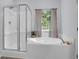 Bright bathroom with a shower, soaking tub, and a window with backyard views at 1126 Rearick Rd, Johns Island, SC 29455