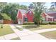 View of red house with driveway and manicured lawn at 1126 Rearick Rd, Johns Island, SC 29455