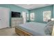 Comfortable bedroom with a wooden bed frame, dresser with TV, and large windows at 1126 Rearick Rd, Johns Island, SC 29455