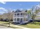 Charming two-story home boasts a double porch and lush green landscaping with a beautiful blue sky backdrop at 117 Red Leaf Blvd, Moncks Corner, SC 29461