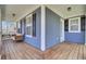 Inviting front porch with wood floors, blue siding, white trim, seating, and black shutters offers a relaxing outdoor space at 117 Red Leaf Blvd, Moncks Corner, SC 29461