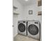 Efficient laundry room features modern washer and dryer set, complemented by stylish floating shelves for organized storage at 117 Red Leaf Blvd, Moncks Corner, SC 29461