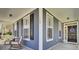 A charming side porch features vinyl siding, black shutters, white trim and rocking chairs at 117 Red Leaf Blvd, Moncks Corner, SC 29461