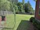 View of a lush green backyard with a sports training net, and a wooden fence at 1297 Segar St, Johns Island, SC 29455