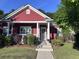Charming red home featuring a cozy front porch, white columns, and well-maintained landscaping at 1297 Segar St, Johns Island, SC 29455