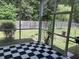 View of a screened porch with checkered floor tile overlooking a lush green backyard at 1297 Segar St, Johns Island, SC 29455