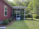 Exterior view of a screened porch and the side of the home with lush landscaping at 1297 Segar St, Johns Island, SC 29455