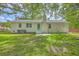 Spacious backyard with a green door and white siding surrounded by lush trees and ample green space at 131 Ponderosa Dr, Ladson, SC 29456