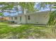 Landscaped backyard featuring white-painted brick house with green door, mature trees and ample space at 131 Ponderosa Dr, Ladson, SC 29456