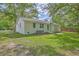 Lawn view of the house exterior with white siding, green door and mature trees surrounding the property at 131 Ponderosa Dr, Ladson, SC 29456