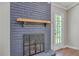 Close up view of a painted brick fireplace with a wooden mantle and black fireplace screen at 131 Ponderosa Dr, Ladson, SC 29456