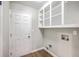 Well-lit mudroom features wood-look flooring, white door, and built-in white storage shelves above utility connections at 131 Ponderosa Dr, Ladson, SC 29456