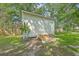 Exterior view of white painted shed in backyard featuring ramp, double doors and mature trees at 131 Ponderosa Dr, Ladson, SC 29456