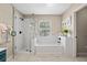 Bright bathroom with a glass-enclosed shower, bathtub, and stylish white subway tile at 1337 Horseshoe Bnd, Mount Pleasant, SC 29464