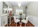 Elegant dining room features a glass table, chandelier, and mirrored accent cabinet on hardwood floors at 139 Spindle Way, Goose Creek, SC 29445