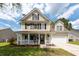 Two story home featuring a cozy front porch and well-manicured yard at 139 Spindle Way, Goose Creek, SC 29445