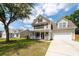 Charming two-story home with a welcoming front porch, attached garage, and well-manicured lawn on a sunny day at 139 Spindle Way, Goose Creek, SC 29445