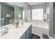 A full bathroom features a double vanity, a soaking tub with tile accents, and neutral wall color at 139 Spindle Way, Goose Creek, SC 29445