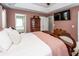 A bedroom with a decorative bed frame, light pink walls, and an ensuite bathroom entrance at 139 Spindle Way, Goose Creek, SC 29445