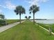 Green pathway lined with palm trees and water views, creating a peaceful and scenic route for residents at 1406 Glencoe Dr, Mount Pleasant, SC 29464
