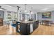 Open kitchen showcasing a kitchen island with seating, wooden floors and lots of natural light at 1406 Glencoe Dr, Mount Pleasant, SC 29464