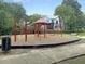 Outdoor playground with a red jungle gym and a swing set, ideal for recreation and community fun at 1406 Glencoe Dr, Mount Pleasant, SC 29464