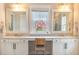 Elegant bathroom featuring double sinks, marble countertop, and a window overlooking greenery at 1445 Lettered Olive Ln, Mount Pleasant, SC 29464