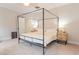 A bright bedroom with a canopy bed, wooden nightstands, and neutral tones at 1445 Lettered Olive Ln, Mount Pleasant, SC 29464